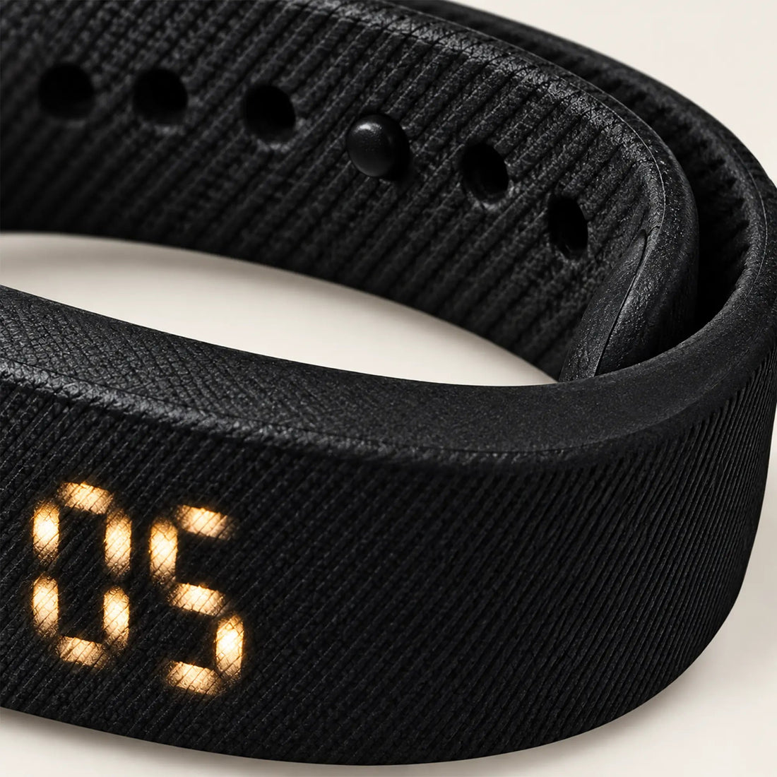 Close-up of the Sovune Nudge wristband showing its textured strap and sizing holes