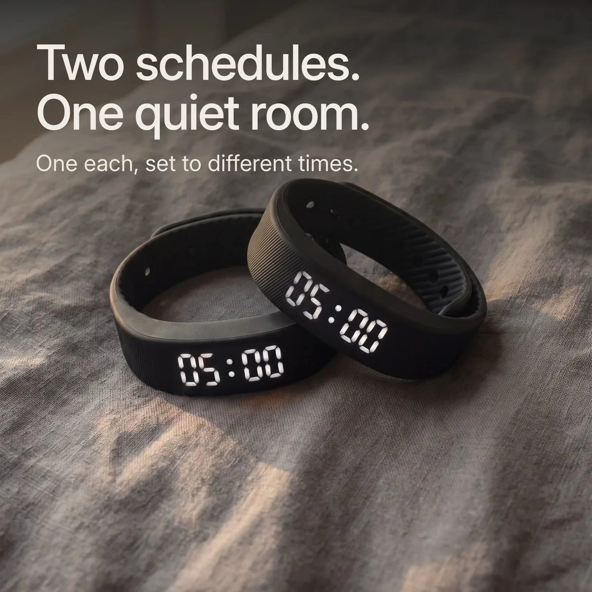 Two Sovune Nudge bands on a bed. The Partner Pack: one each, set to different times.